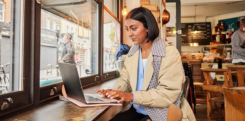 Woman working at a laptop lone in café