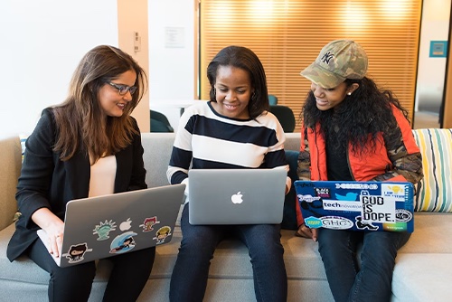 Three coworkers on laptops working together