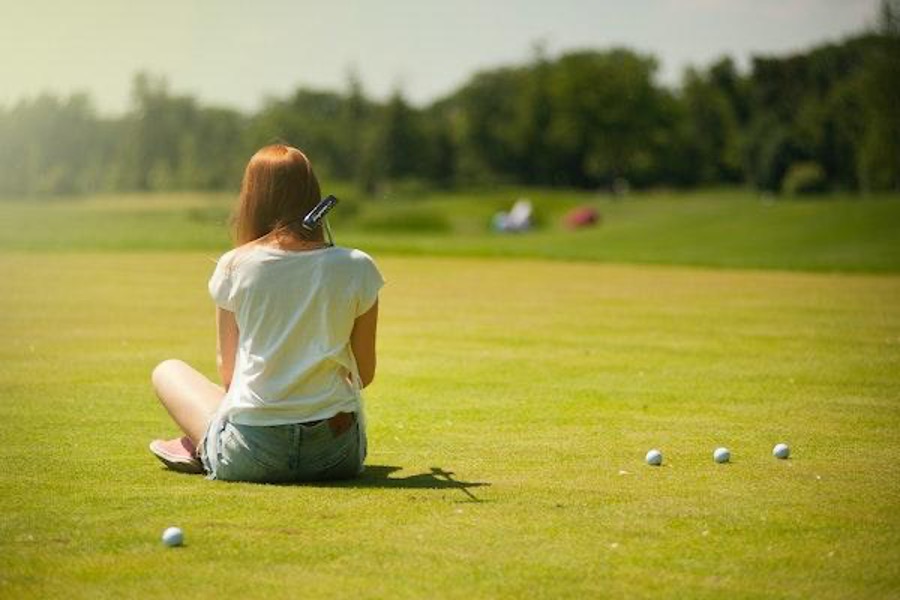 A woman sitting on the grass.