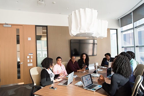 Coworkers having a training meeting about corrective action plans in a conference room
