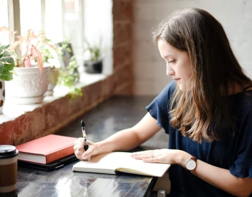 Woman writing her performance improvement plan