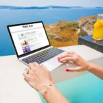 Person with a Laptop on a Deck Looking Out over a European body of water with houses in the distance
