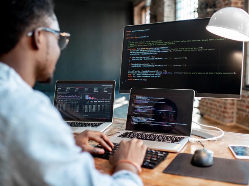 how to make money on fiverr - programmer working on multiple screes