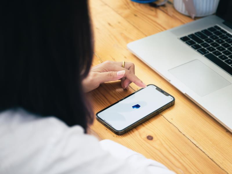 how to make money on fiverr - person using PayPal on a smartphone