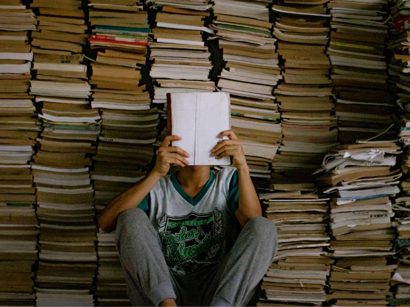 book summaries reader with pile of books behind