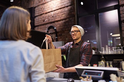 Man giving to go bag to customer