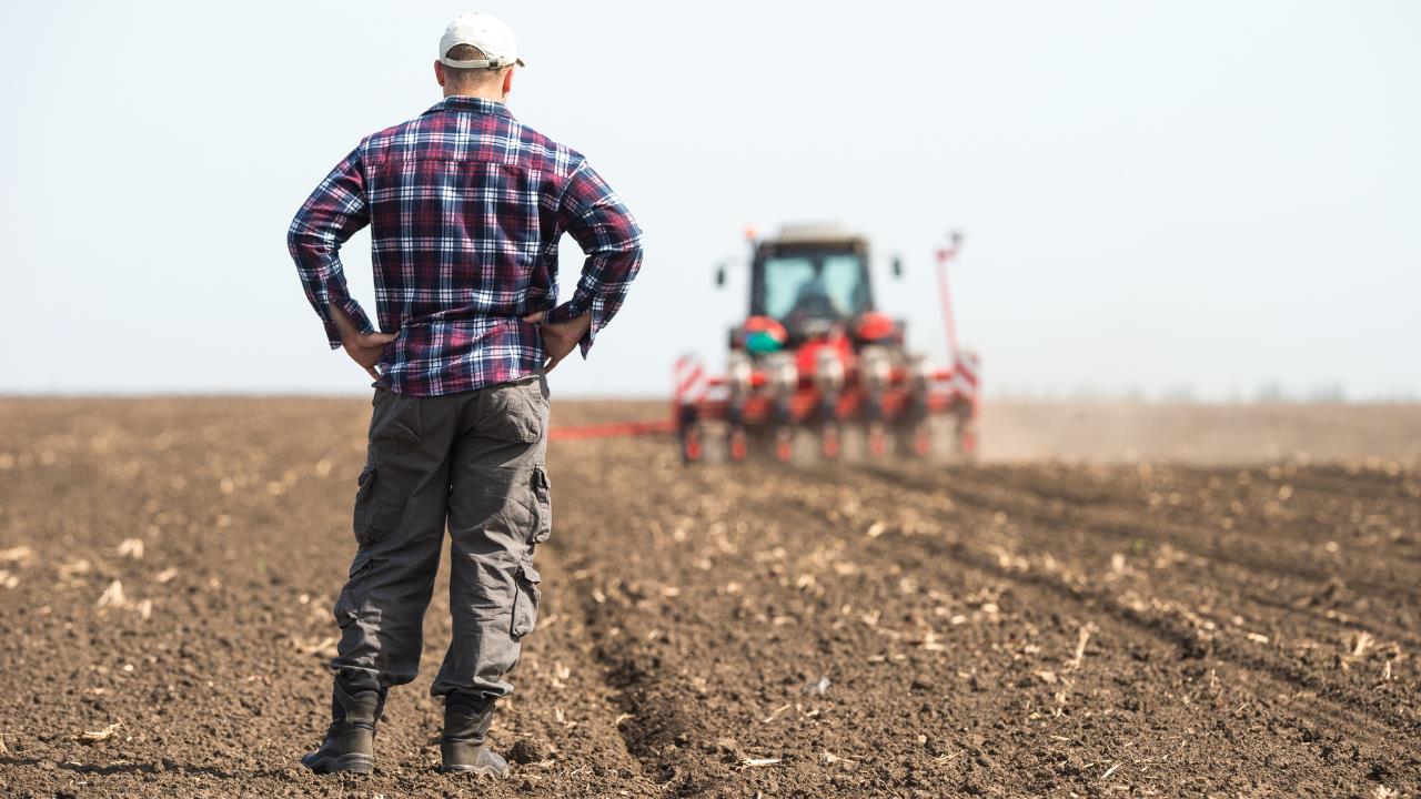 how to start a farm - young farmer on farmland