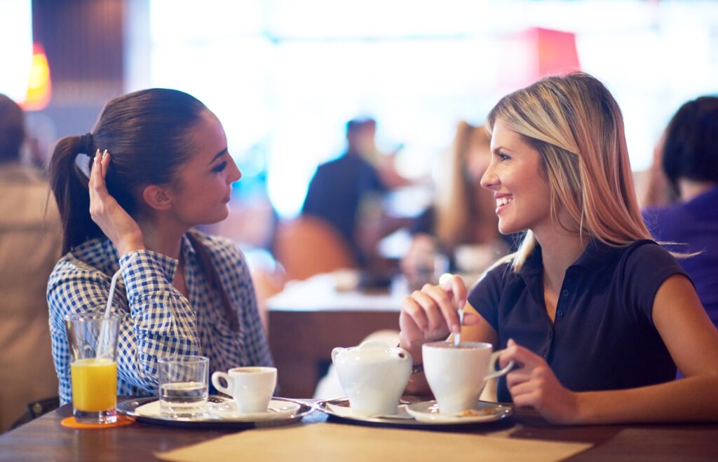 Two women chatting and having coffee together