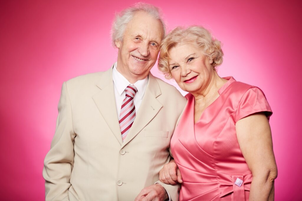 Elderly couple standing side by side and smiling