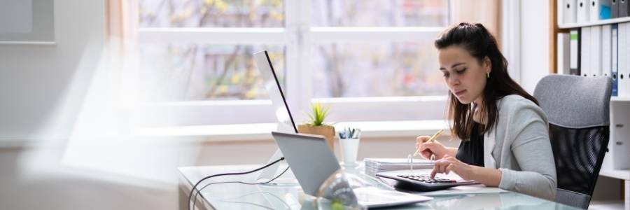 entrepreneur working on laptop in office thinking through the need to write a business plan